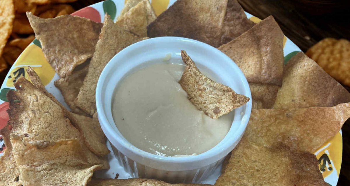 Oil-free homemade hummus in a cup ready to serve with chips