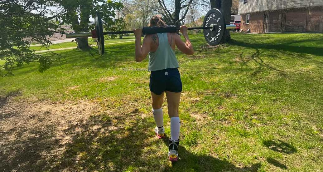 susan-barbell-uphill Susan walking uphill with a barbell across her shoulders
