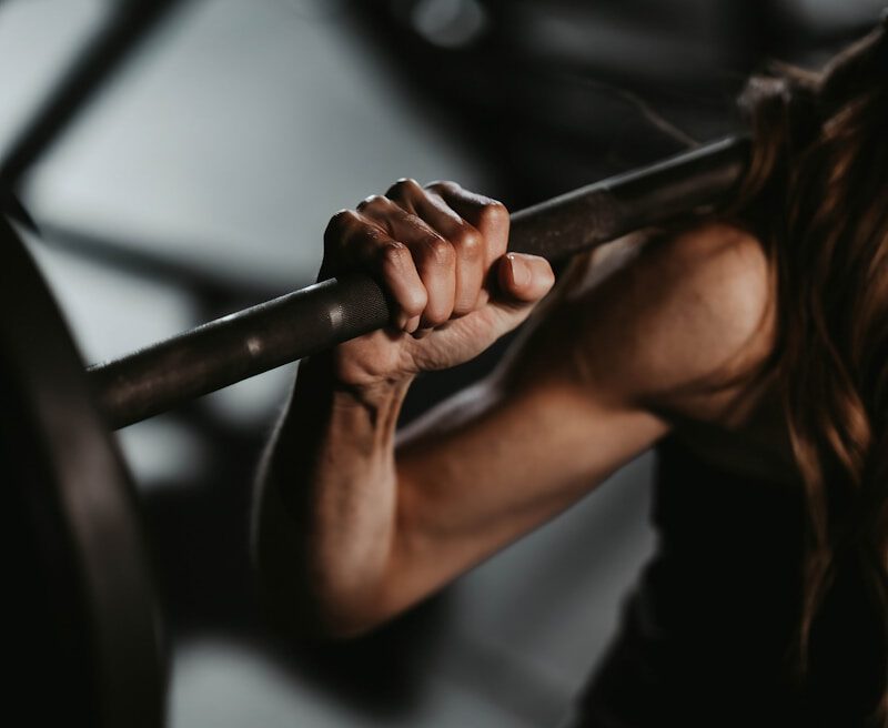 A woman lifting a barbell in a gym